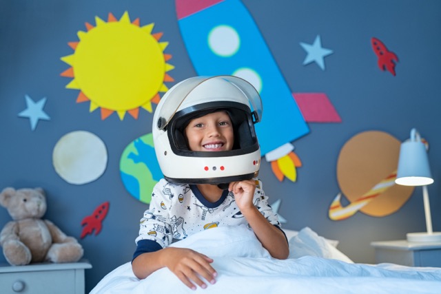 Kid plays astronaut in his decorated bedroom