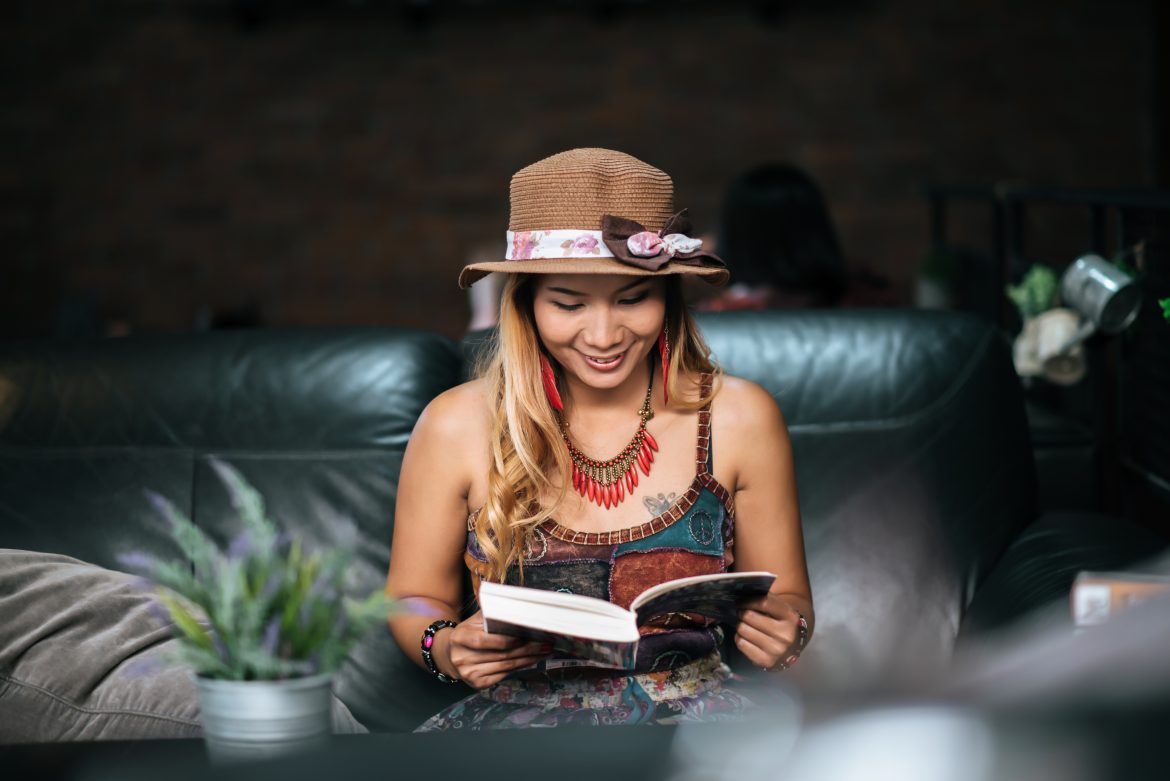Young woman  reading book and fresh cup of coffee on the table